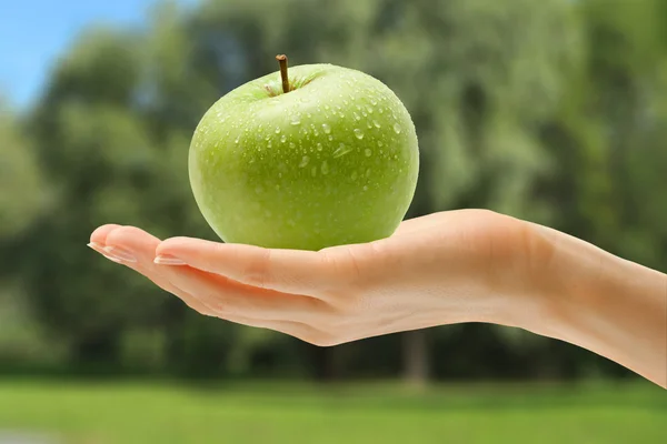 Mano femminile con mela verde — Foto Stock