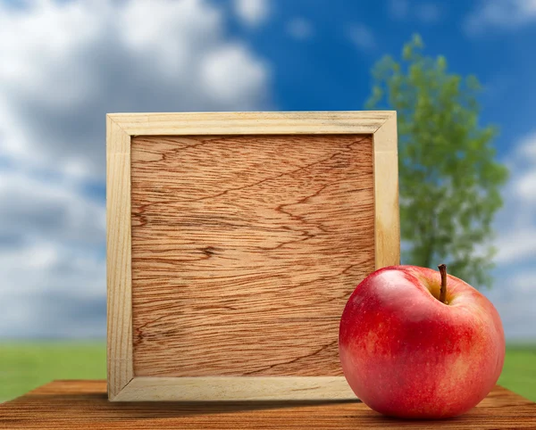 Red apple with wooden frame — Stock Photo, Image