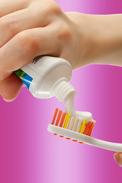 Tandenborstel en tandpasta in vrouwelijke handen — Stockfoto