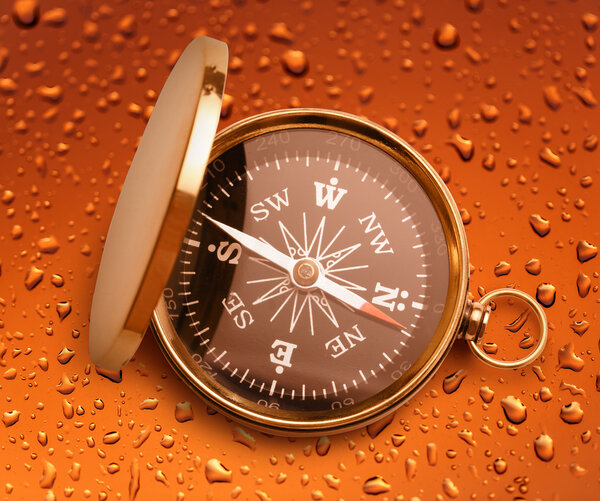 компас на фоне капли дождя
