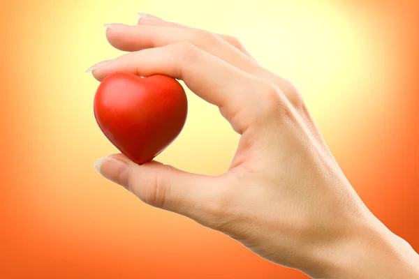 Mano femminile con cuore rosso — Foto Stock