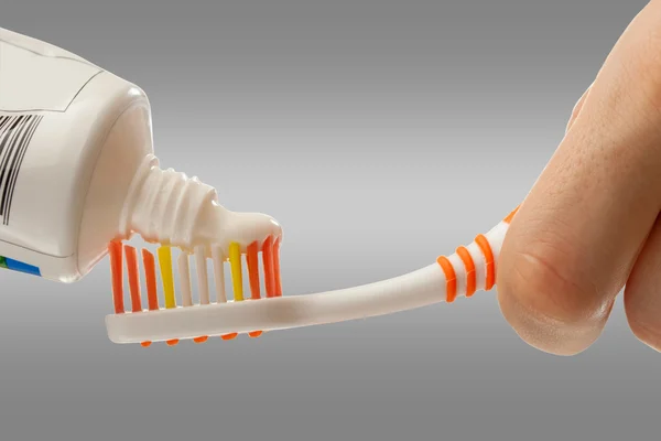 Cepillo de dientes y pasta de dientes en manos femeninas — Foto de Stock
