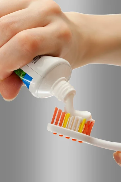 Toothbrush and toothpaste in female hands — Stock Photo, Image