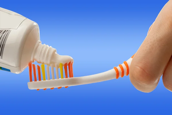 Toothbrush and toothpaste in female hands — Stock Photo, Image