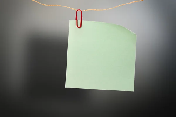 Adesivo verde em branco e clipe vermelho — Fotografia de Stock