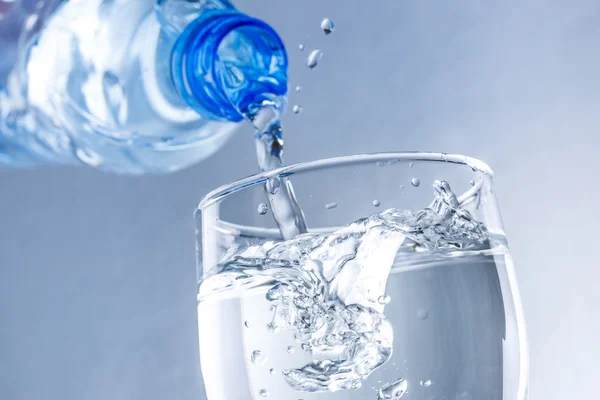 Wasser aus der Flasche ins Glas gießen — Stockfoto