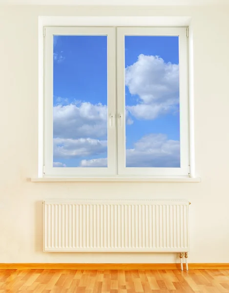 Radiateur et fenêtre avec vue ciel bleu — Photo