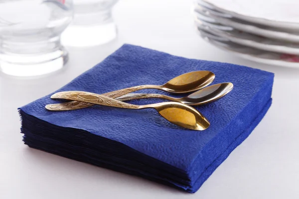 Napkins with spoons, plates and glasses — Stock Photo, Image