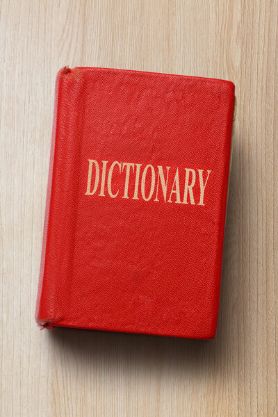 Старый словарь на деревянном фоне
