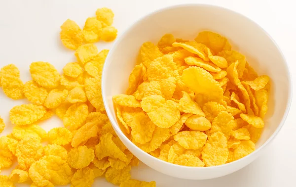 Gele cornflakes op wit — Stockfoto