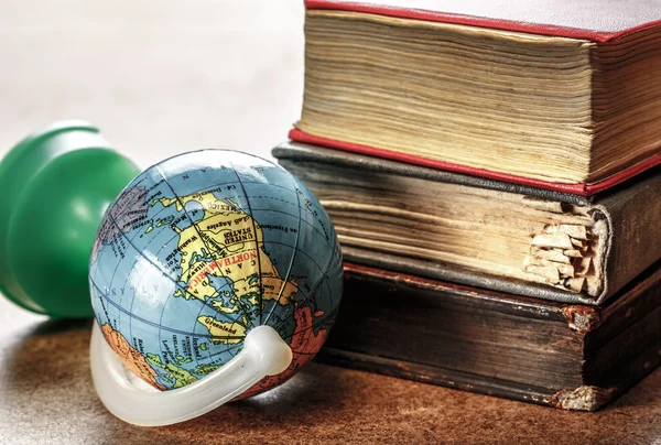 Pile of old books and globe — Stock Photo, Image