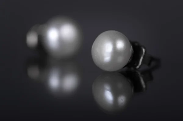 Earrings with pearls on a black background. — Stock Photo, Image