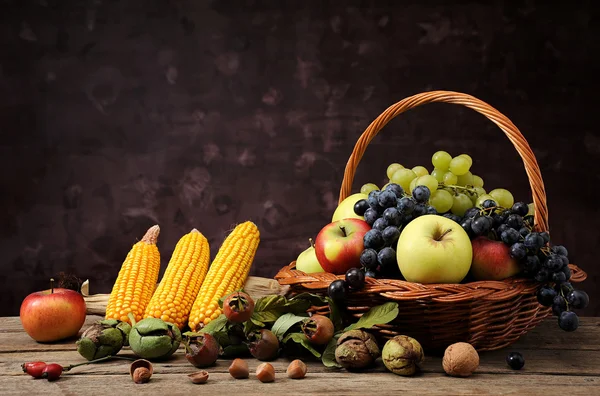 Fruit in wicker baskets and corn — Stock Photo, Image