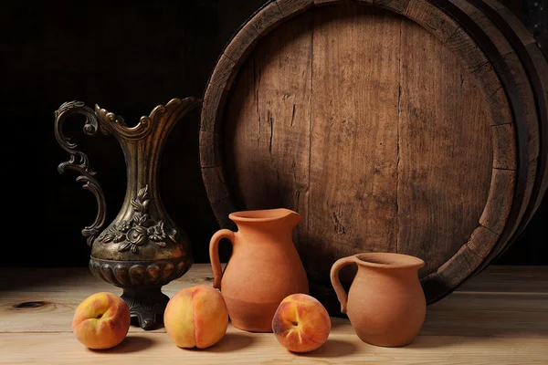 Wooden barrel, peach and ceramic dishes — Stock Photo, Image