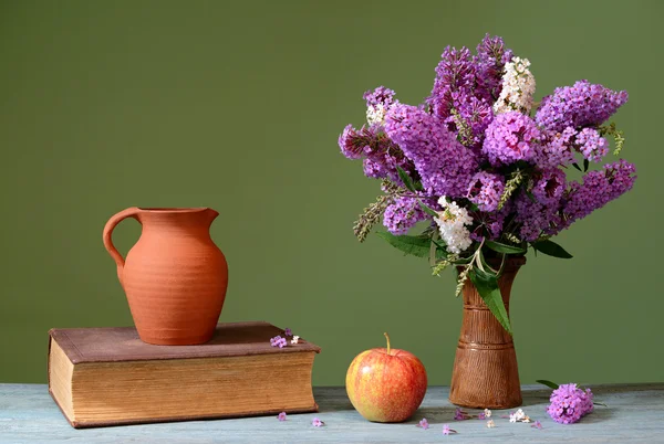 Budleja v keramické vázy, apple a knihy — Stock fotografie