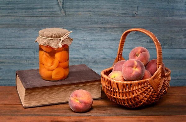 Fresh peaches in wicker baskets and books — Stock Photo, Image