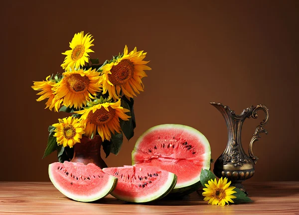Sunflowers in a vase and fresh watermelon — Stock Photo, Image