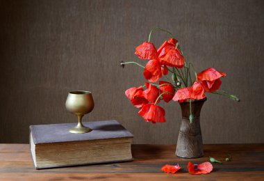 Kırmızı poppies seramik vazo ve kitaplar