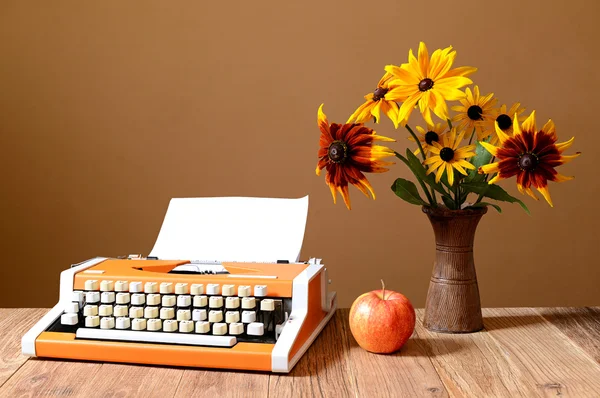 Typewriter apples and flowers in a vase — Stock Photo, Image