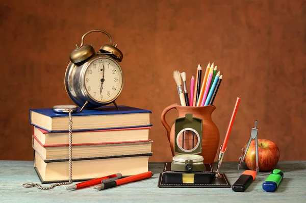 Libros, Reloj despertador, útiles escolares y una manzana —  Fotos de Stock