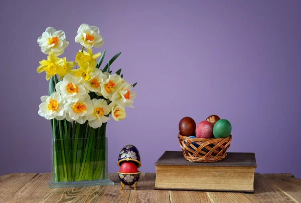 Huevos de Pascua de colores, libros y flores en un jarrón — Foto de Stock