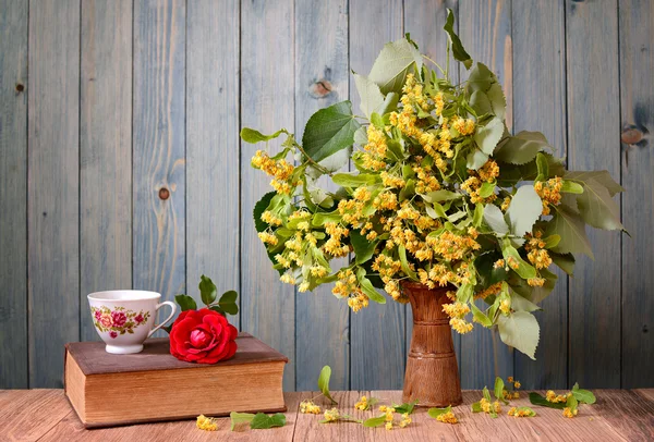 Flores de tília em um vaso e livros — Fotografia de Stock