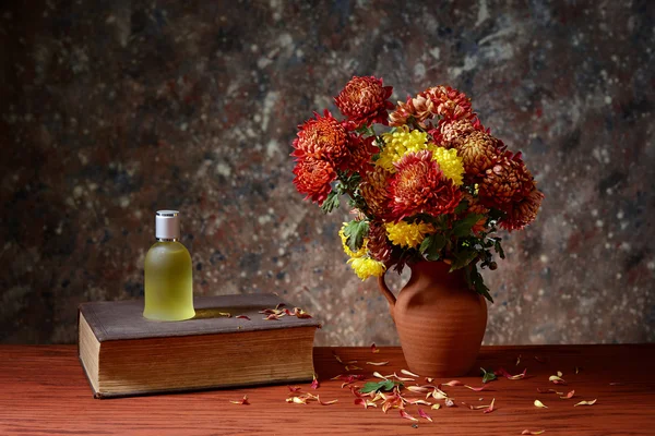 Fiori in vaso di ceramica, libri e profumo in bottiglia — Foto Stock