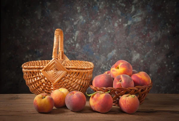 Fresh peaches and wicker basket — Stock Photo, Image