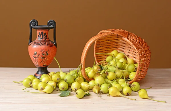 Söta päron spillt från en vävda korg — Stockfoto