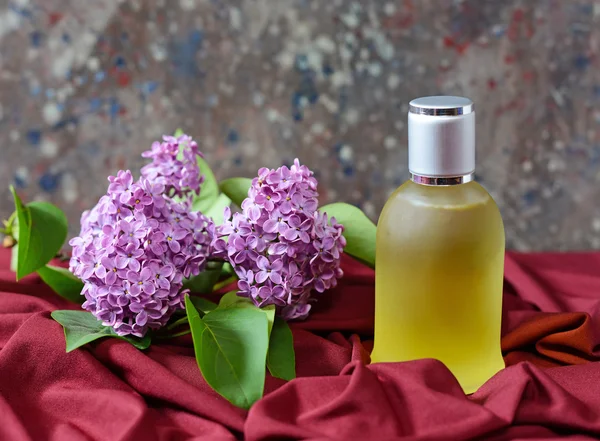 Parfume in a bottle with lilac flowers