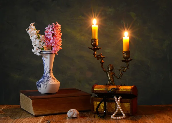 Fiori in un vaso, libri e candeliere — Foto Stock