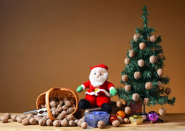 Wallnuts in a wicker basket with a pine tree and santa — Stock Photo, Image
