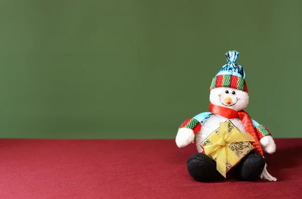 Snowman holding a new years gift — Stock Photo, Image