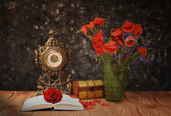 Poppy flowers in a vase with a book — Stock Photo, Image