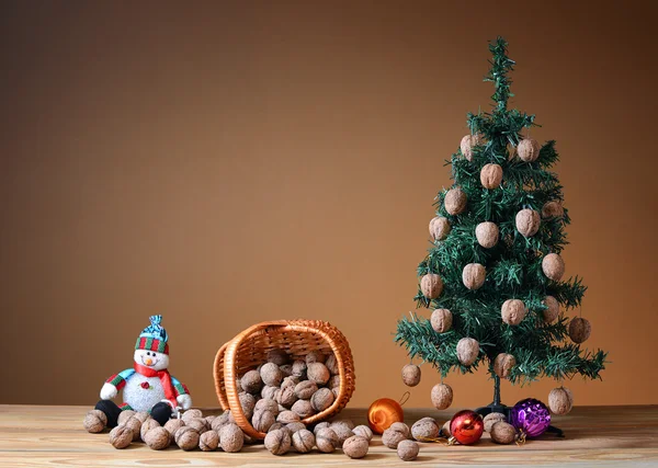 Wallnuts in a wicker basket with a pine tree — Stock Photo, Image