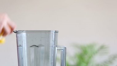 El blender portakal parçaları koyarak