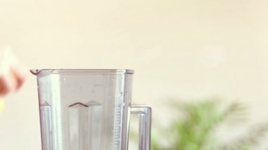 El blender portakal parçaları koyarak