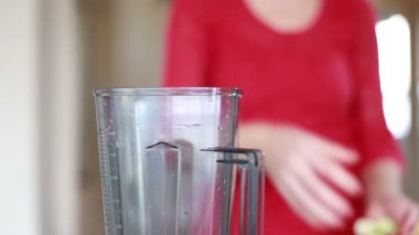 Kadın blender içine koyarak elma