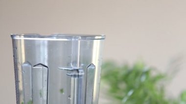 woman   putting vegetables  into blender