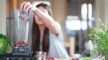 Karıştırıcıda meyve koyarak kadın