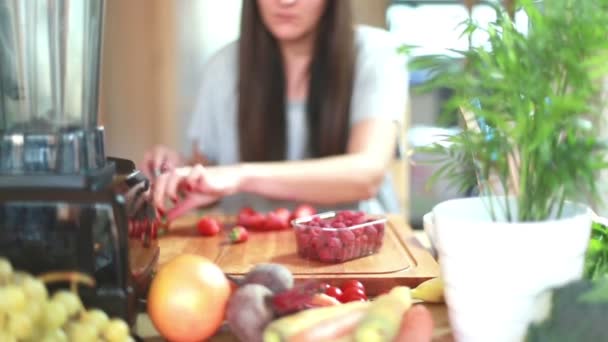 Mujer joven cortando fresas — Vídeos de Stock