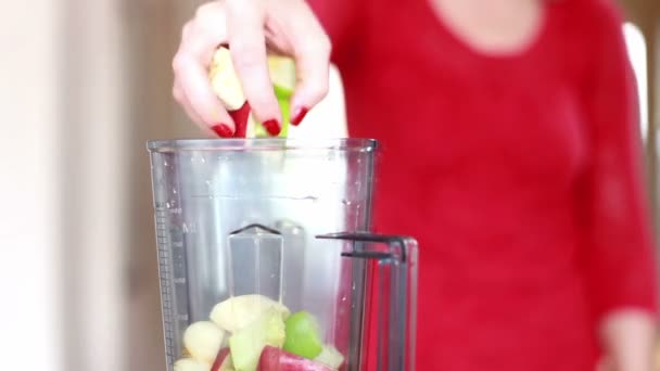 Mano de mujer poniendo frutas en la licuadora — Vídeo de stock