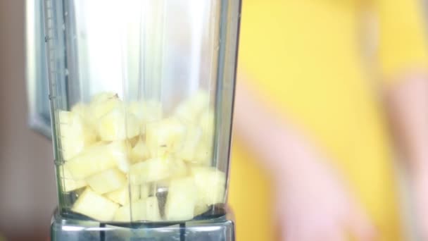 Vrouw zetten ananas blender — Stockvideo