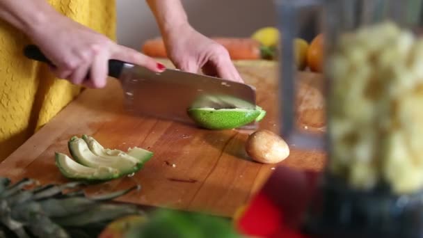 Mujer cortando aguacate antes de mezclar — Vídeo de stock