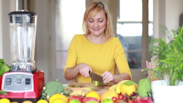 Girl slicing kiwi for smoothie — Wideo stockowe