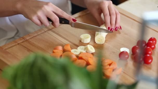 Vrouw handen snijden banaan — Stockvideo