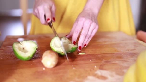 Женские руки режут авокадо — стоковое видео