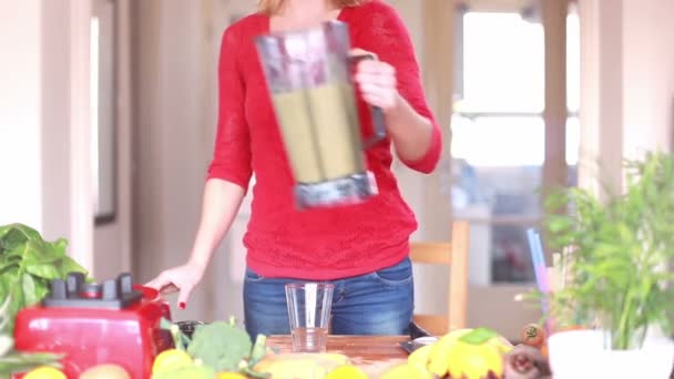 Frau schüttet Smoothie ins Glas — Stockvideo