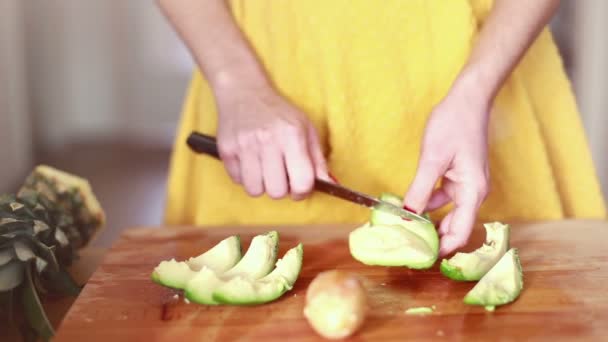 Frau schneidet Avocado mit der Hand — Stockvideo