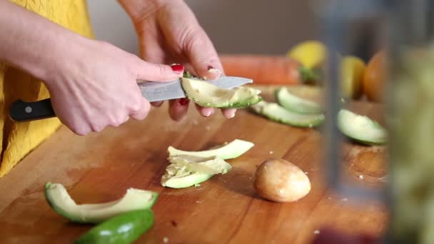 Vrouw handen snijden van avocado — Stockvideo